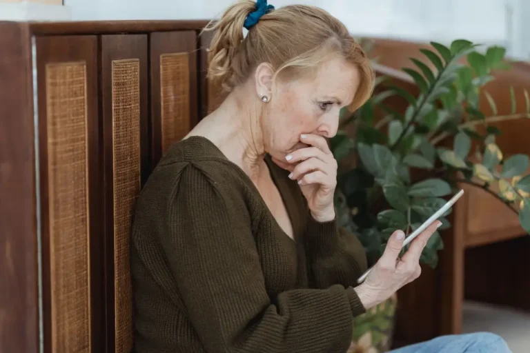Femme senior pensive devant son téléphone
